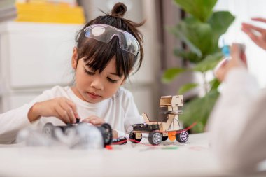 Asyalı öğrenciler evlerinde robot arabaları ve elektronik tahta kablolarını STEM, STEAM, matematik mühendisliği, bilim teknolojisi bilgisayar kodlarını çocuk konsepti için robotikte kodlayarak öğreniyorlar..