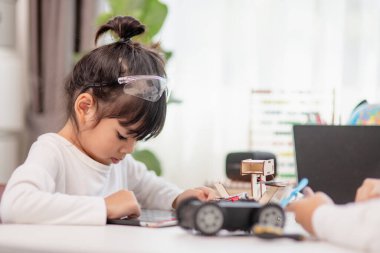 Asyalı öğrenciler evlerinde robot arabaları ve elektronik tahta kablolarını STEM, STEAM, matematik mühendisliği, bilim teknolojisi bilgisayar kodlarını çocuk konsepti için robotikte kodlayarak öğreniyorlar..