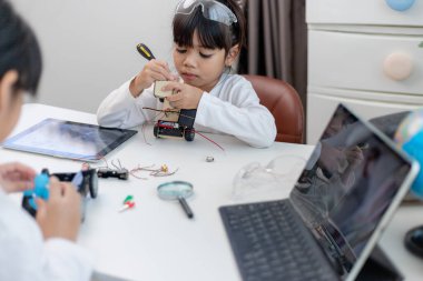 Asyalı öğrenciler evlerinde robot arabaları ve elektronik tahta kablolarını STEM, STEAM, matematik mühendisliği, bilim teknolojisi bilgisayar kodlarını çocuk konsepti için robotikte kodlayarak öğreniyorlar..