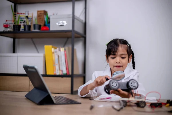 Asian students learn at home by coding robot cars and electronic board cables in STEM, STEAM, mathematics engineering science technology computer code in robotics for kids' concepts.