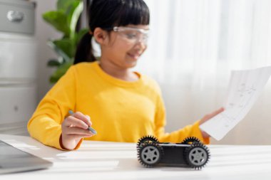Asyalı öğrenciler evlerinde robot arabaları ve elektronik tahta kablolarını STEM, STEAM, matematik mühendisliği, bilim teknolojisi bilgisayar kodlarını çocuk konsepti için robotikte kodlayarak öğreniyorlar..