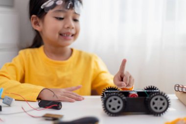 Asyalı öğrenciler evlerinde robot arabaları ve elektronik tahta kablolarını STEM, STEAM, matematik mühendisliği, bilim teknolojisi bilgisayar kodlarını çocuk konsepti için robotikte kodlayarak öğreniyorlar..