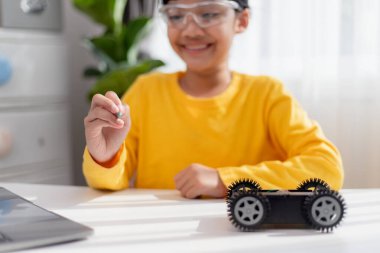 Asyalı öğrenciler evlerinde robot arabaları ve elektronik tahta kablolarını STEM, STEAM, matematik mühendisliği, bilim teknolojisi bilgisayar kodlarını çocuk konsepti için robotikte kodlayarak öğreniyorlar..