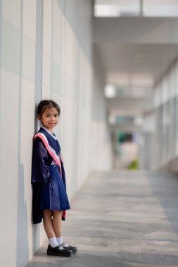 Happy Asian girls in graduation gowns on their graduation day at school.Graduation concept with copy space.	