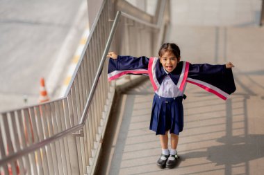 Happy Asian girls in graduation gowns on their graduation day at school.Graduation concept with copy space.	