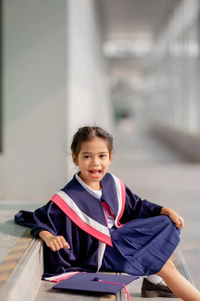 stock image Happy Asian girls in graduation gowns on their graduation day at school.Graduation concept with copy space.	