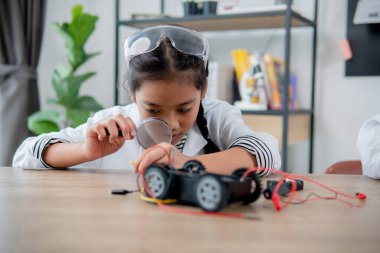 Asian students learn at home in coding robot cars and electronic board cables in STEM, STEAM, mathematics engineering science technology computer code in robotics for kids concept.