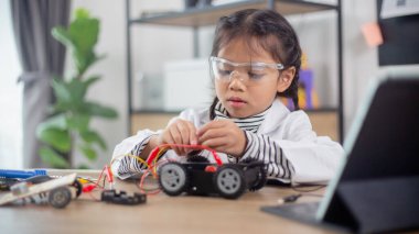 Asian students learn at home in coding robot cars and electronic board cables in STEM, STEAM, mathematics engineering science technology computer code in robotics for kids concept.