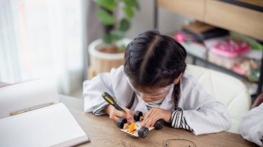 Asian students learn at home in coding robot cars and electronic board cables in STEM, STEAM, mathematics engineering science technology computer code in robotics for kids concept.