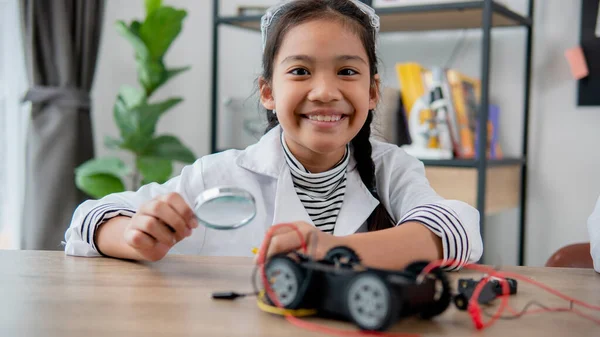 Asian students learn at home in coding robot cars and electronic board cables in STEM, STEAM, mathematics engineering science technology computer code in robotics for kids concept.