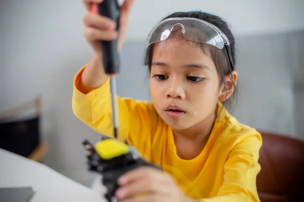 STEM education concept. Asian students learn at home by coding robot arms in STEM, mathematics engineering science technology computer code in robotics for kids\' concepts.