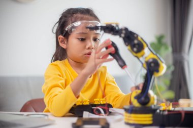 BTMM eğitim konsepti. Asyalı öğrenciler evde robot kollarını STEM 'de kodlayarak öğreniyorlar, matematik mühendisliği bilim teknolojisi bilgisayar kodları çocukların kavramları için robotik..