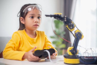 BTMM eğitim konsepti. Asyalı öğrenciler evde robot kollarını STEM 'de kodlayarak öğreniyorlar, matematik mühendisliği bilim teknolojisi bilgisayar kodları çocukların kavramları için robotik..