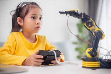 BTMM eğitim konsepti. Asyalı öğrenciler evde robot kollarını STEM 'de kodlayarak öğreniyorlar, matematik mühendisliği bilim teknolojisi bilgisayar kodları çocukların kavramları için robotik..
