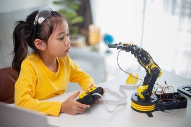 BTMM eğitim konsepti. Asyalı öğrenciler evde robot kollarını STEM 'de kodlayarak öğreniyorlar, matematik mühendisliği bilim teknolojisi bilgisayar kodları çocukların kavramları için robotik..