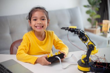 BTMM eğitim konsepti. Asyalı öğrenciler evde robot kollarını STEM 'de kodlayarak öğreniyorlar, matematik mühendisliği bilim teknolojisi bilgisayar kodları çocukların kavramları için robotik..