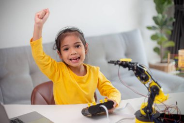 BTMM eğitim konsepti. Asyalı öğrenciler evde robot kollarını STEM 'de kodlayarak öğreniyorlar, matematik mühendisliği bilim teknolojisi bilgisayar kodları çocukların kavramları için robotik..