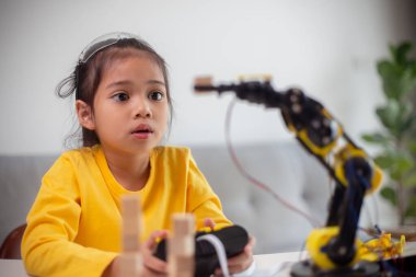 BTMM eğitim konsepti. Asyalı öğrenciler evde robot kollarını STEM 'de kodlayarak öğreniyorlar, matematik mühendisliği bilim teknolojisi bilgisayar kodları çocukların kavramları için robotik..
