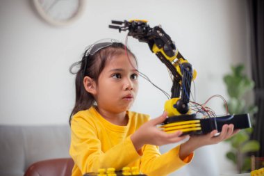 BTMM eğitim konsepti. Asyalı öğrenciler evde robot kollarını STEM 'de kodlayarak öğreniyorlar, matematik mühendisliği bilim teknolojisi bilgisayar kodları çocukların kavramları için robotik..