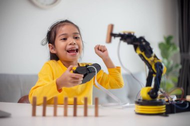 BTMM eğitim konsepti. Asyalı öğrenciler evde robot kollarını STEM 'de kodlayarak öğreniyorlar, matematik mühendisliği bilim teknolojisi bilgisayar kodları çocukların kavramları için robotik..