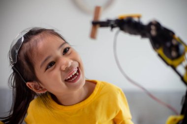 BTMM eğitim konsepti. Asyalı öğrenciler evde robot kollarını STEM 'de kodlayarak öğreniyorlar, matematik mühendisliği bilim teknolojisi bilgisayar kodları çocukların kavramları için robotik..