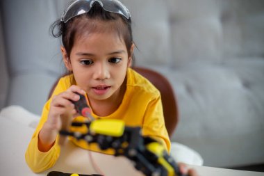 BTMM eğitim konsepti. Asyalı öğrenciler evde robot kollarını STEM 'de kodlayarak öğreniyorlar, matematik mühendisliği bilim teknolojisi bilgisayar kodları çocukların kavramları için robotik..
