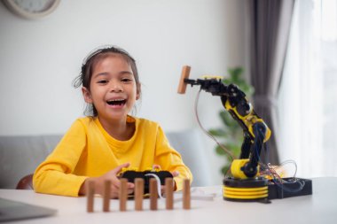 BTMM eğitim konsepti. Asyalı öğrenciler evde robot kollarını STEM 'de kodlayarak öğreniyorlar, matematik mühendisliği bilim teknolojisi bilgisayar kodları çocukların kavramları için robotik..