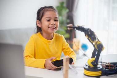 BTMM eğitim konsepti. Asyalı öğrenciler evde robot kollarını STEM 'de kodlayarak öğreniyorlar, matematik mühendisliği bilim teknolojisi bilgisayar kodları çocukların kavramları için robotik..