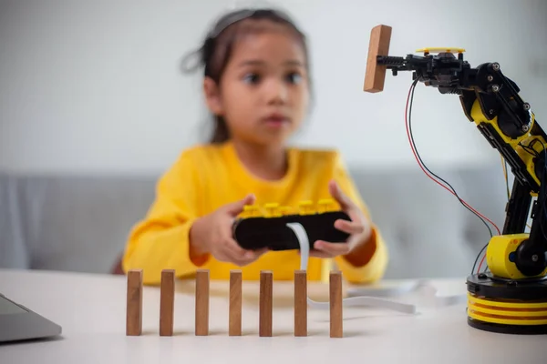 STEM education concept. Asian students learn at home by coding robot arms in STEM, mathematics engineering science technology computer code in robotics for kids' concepts.