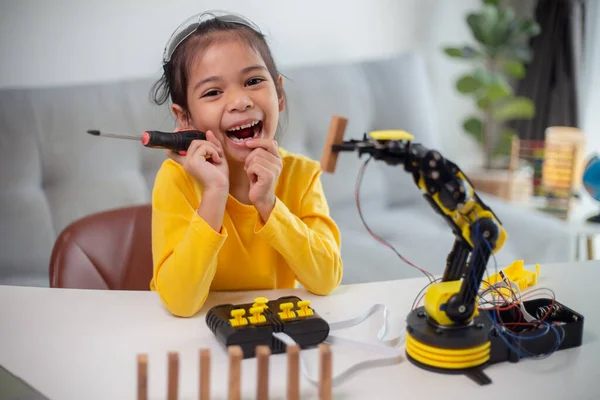 STEM education concept. Asian students learn at home by coding robot arms in STEM, mathematics engineering science technology computer code in robotics for kids\' concepts.