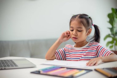 Asyalı çocuk öğrenciler yeni fikirlerin ne olduğunu öğrenmek için ödev yapıyorlar. Eğitim kavramı.