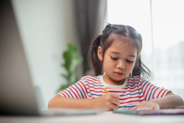 Asyalı çocuk öğrenciler yeni fikirlerin ne olduğunu öğrenmek için ödev yapıyorlar. Eğitim kavramı.