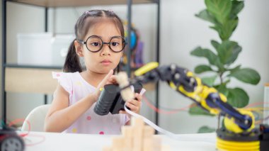 BTMM eğitim konsepti. Asyalı öğrenciler evde robot kollarını STEM 'de kodlayarak öğreniyorlar, matematik mühendisliği bilim teknolojisi bilgisayar kodları çocukların kavramları için robotik.