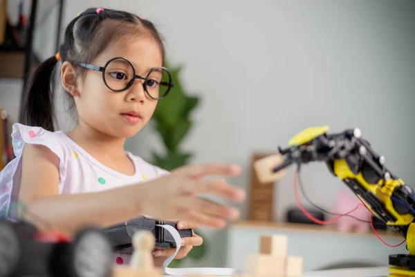 STEM education concept. Asian students learn at home by coding robot arms in STEM, mathematics engineering science technology computer code in robotics for kids' concepts