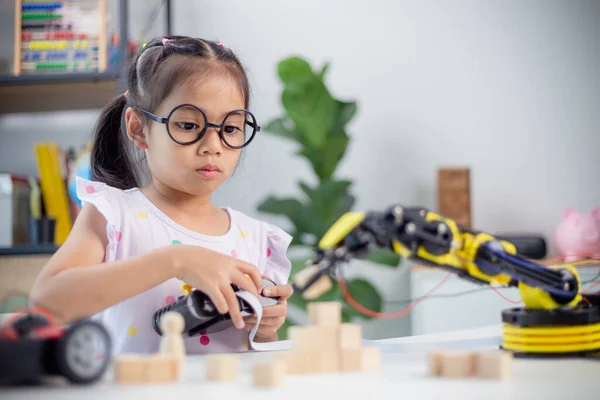 STEM education concept. Asian students learn at home by coding robot arms in STEM, mathematics engineering science technology computer code in robotics for kids\' concepts