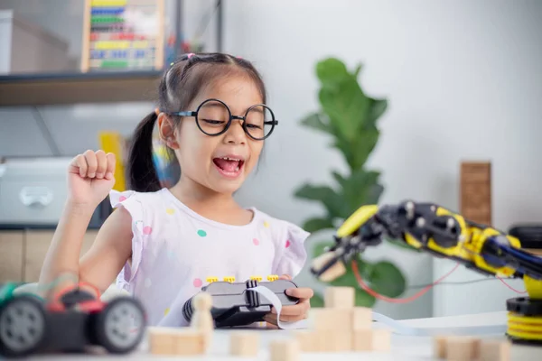 stock image STEM education concept. Asian students learn at home by coding robot arms in STEM, mathematics engineering science technology computer code in robotics for kids' concepts