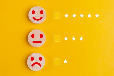 Müşteri konseptini gözden geçirir. Sarı arka planda gülen yüzlü ahşap düğmeler