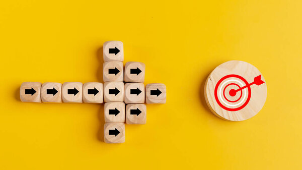 Concept of target marketing. Wooden blocks with arrow and target on blue background. Success concept. Business achievement goal and objective target concept.