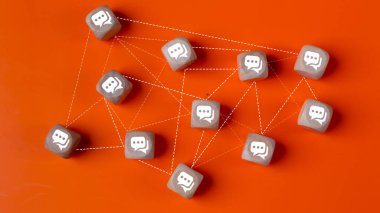 Çevrimiçi iletişim ya da sosyal ağ kavramı. Konuşma baloncukları olan tahta küpler birbirine çizgilerle bağlı..