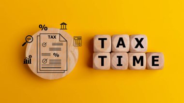 Tax time concept with text on wooden cubes on a yellow background. Tax payment reminder or annual taxation concept. clipart