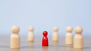 Etkilemek ve güçlendirmek için bir ekiple birlikte duran tahta bir figür. Liderlik kavramı, başarılı yarışma galibi ve yeni normal bir yaşam tarzı için nüfuzlu ve sosyal mesafeli lider.