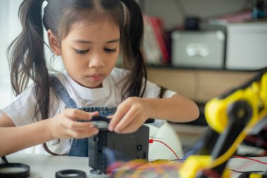 BTMM eğitim konsepti. Asyalı genç kız robot tasarımı öğreniyor.