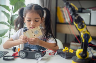 BTMM eğitim konsepti. Asyalı genç kız robot tasarımı öğreniyor.