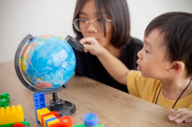 Asyalı tatlı erkek ve kız kardeşler evdeki oturma odasındaki masada oyuncak bloğu tasarımcısıyla oynuyorlar. Kardeşlerin bağ kurması, arkadaşlık ve öğrenme kavramı çocuk gelişimi için oyun aktivitesi yoluyla.