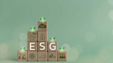 ESG çevre, sosyal ve yönetim kavramı. Sürdürülebilir ve etik bir iş. İş eliyle yeşil toprak simgesi arasında ESG metin içeren ahşap küplerName 