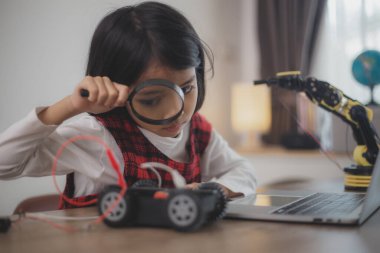 BTMM eğitim konsepti. Asyalı öğrenciler evde robot kollarını STEM 'de kodlayarak öğreniyorlar, matematik mühendisliği bilim teknolojisi bilgisayar kodları çocukların kavramları için robotik..