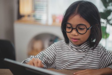 Dizüstü bilgisayar kullanan sevimli Asyalı küçük kız çocukları online bir e-öğrenme sisteminde çalışıyorlar..