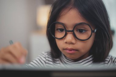 Dizüstü bilgisayar kullanan sevimli Asyalı küçük kız çocukları online bir e-öğrenme sisteminde çalışıyorlar..