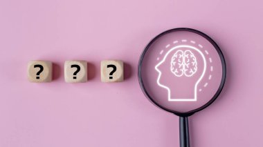 Beyni olan el ele tutuşan büyüteç ve pembe arka planda problem çözme ve patent yenileme kavramına odaklanmak için soru işareti..