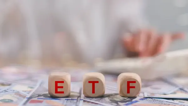 exchange-traded fund (ETF) is a type of pooled investment security that operates much like a mutual fund. The word is written on money and background